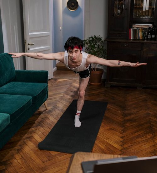 Person holding a balancing yoga pose, showing focus and strength.